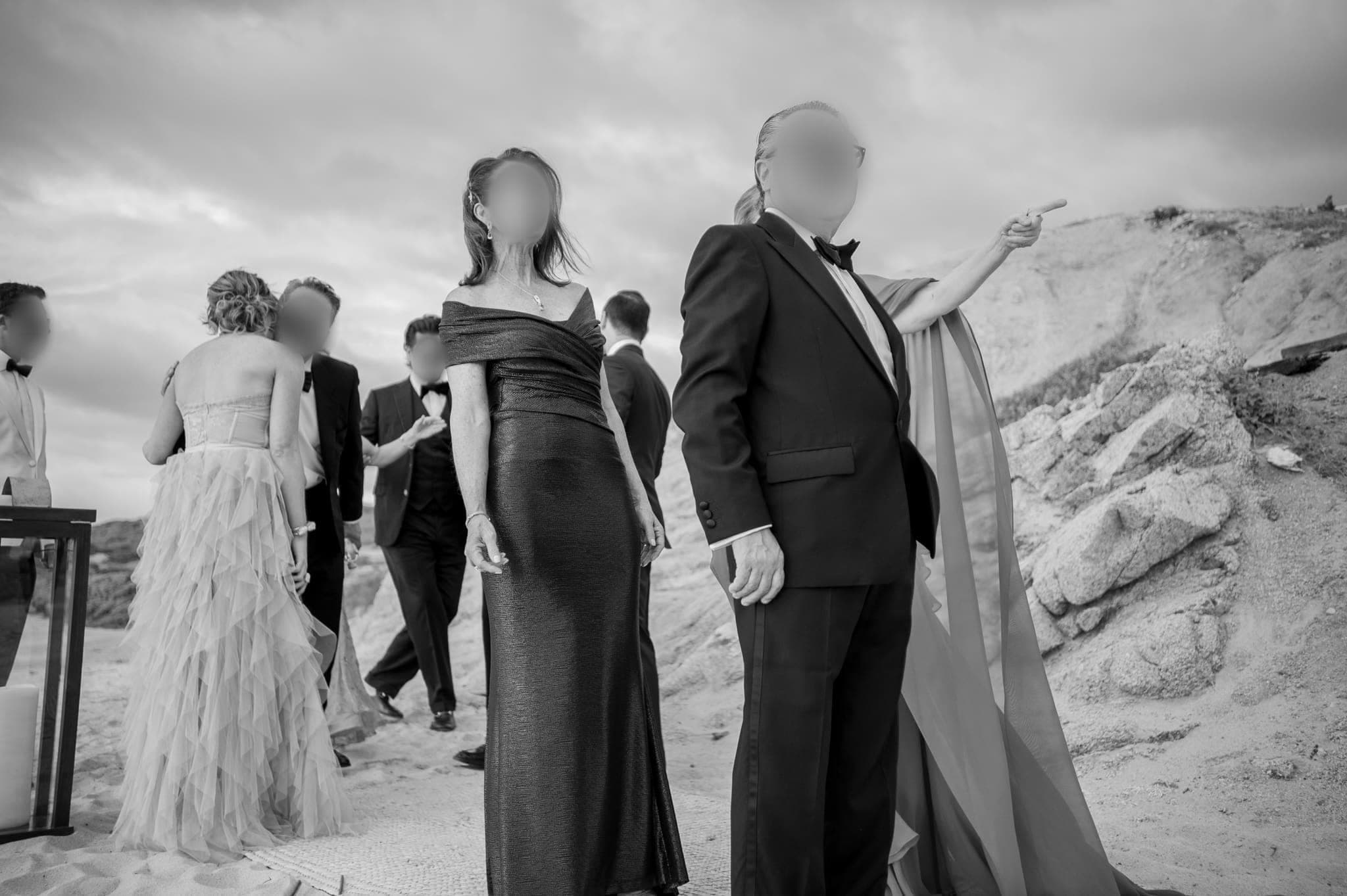 Invitados elegantes caminando entre rocas, fotografía en blanco y negro