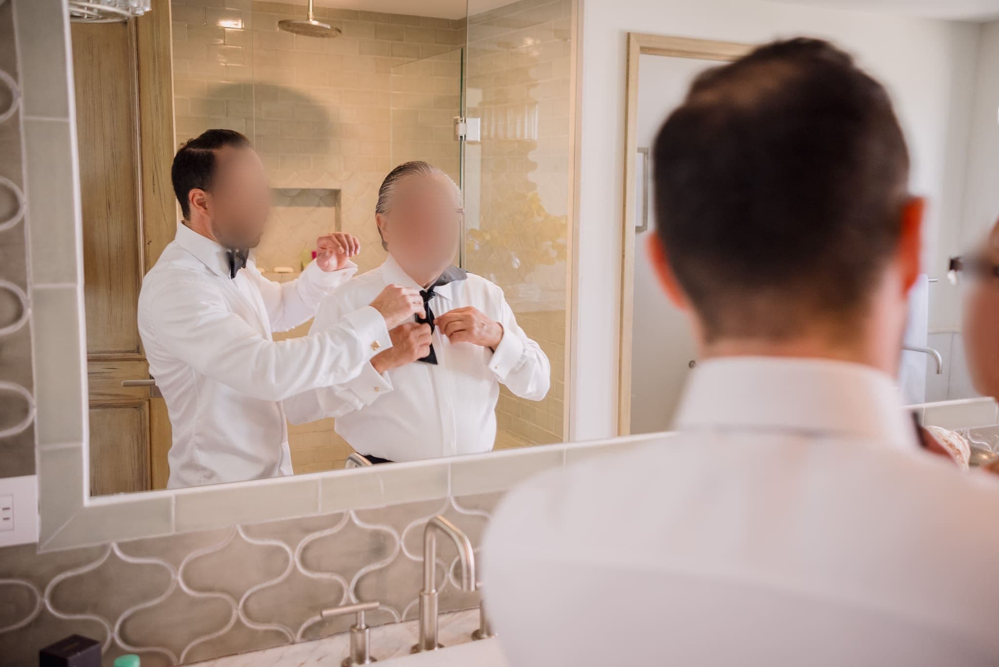 Ajustando el corbatín frente al espejo del baño