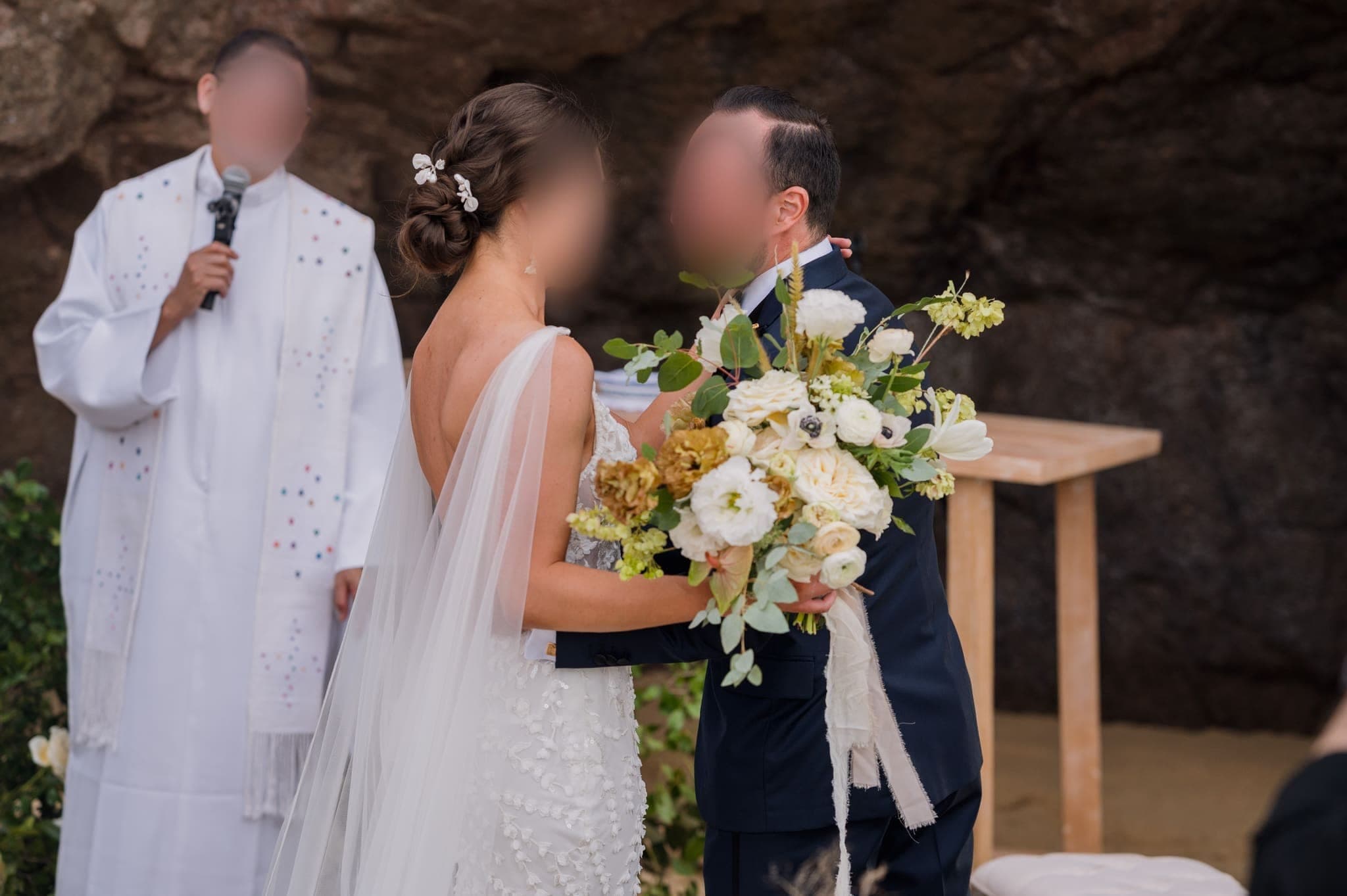 Los novios sonríen ante el oficiante en el altar