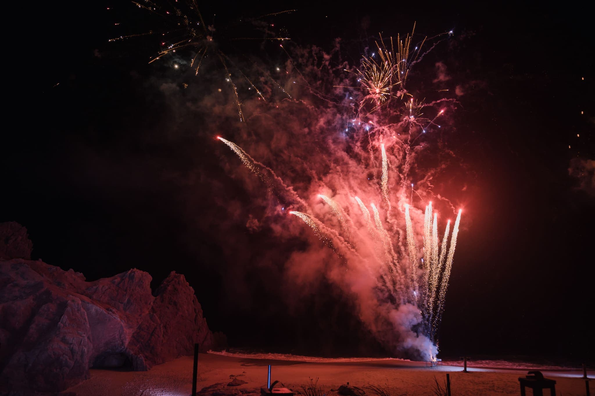 Fuegos artificiales iluminando las rocas de noche