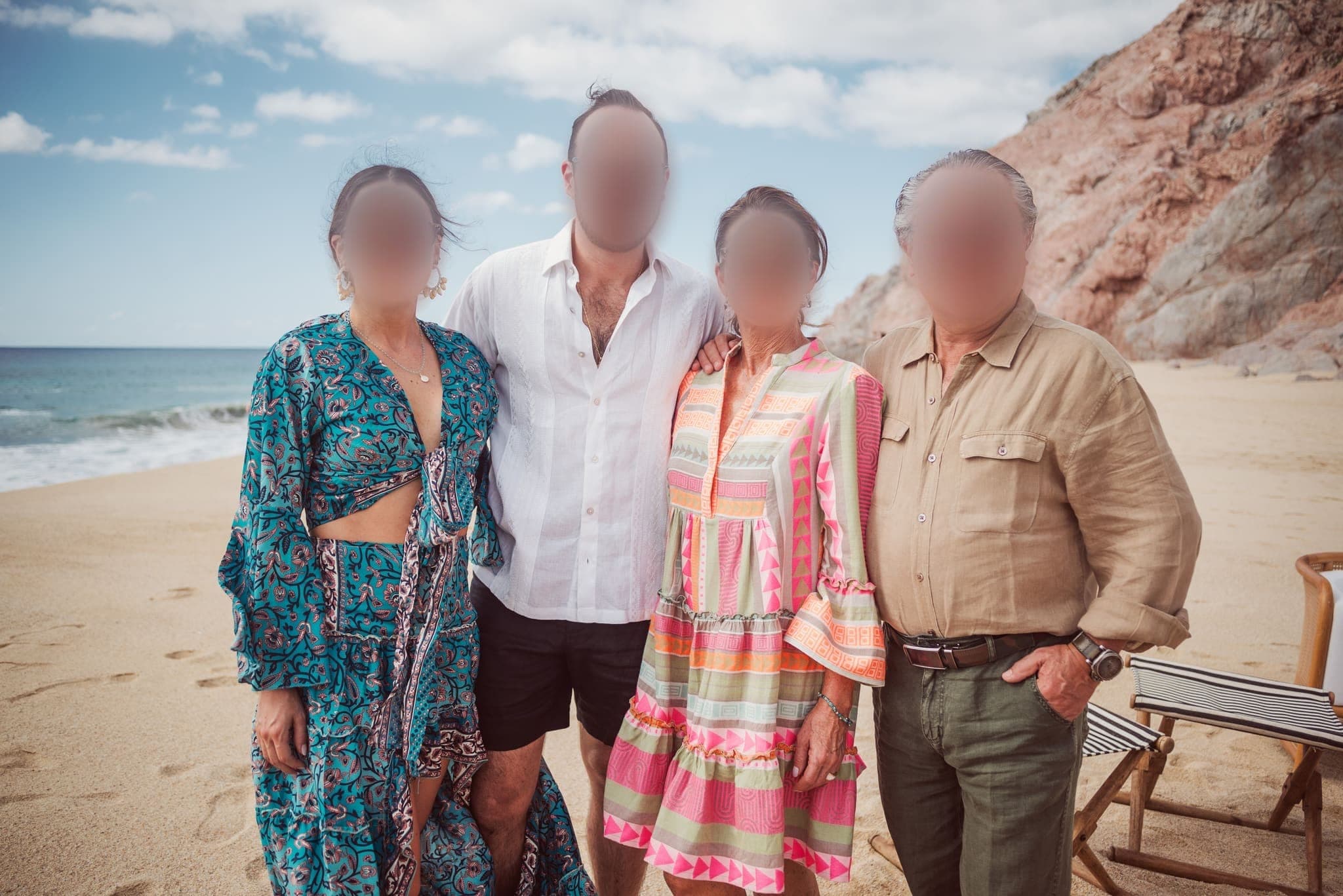 Familia sonriente en la playa entre las rocas
