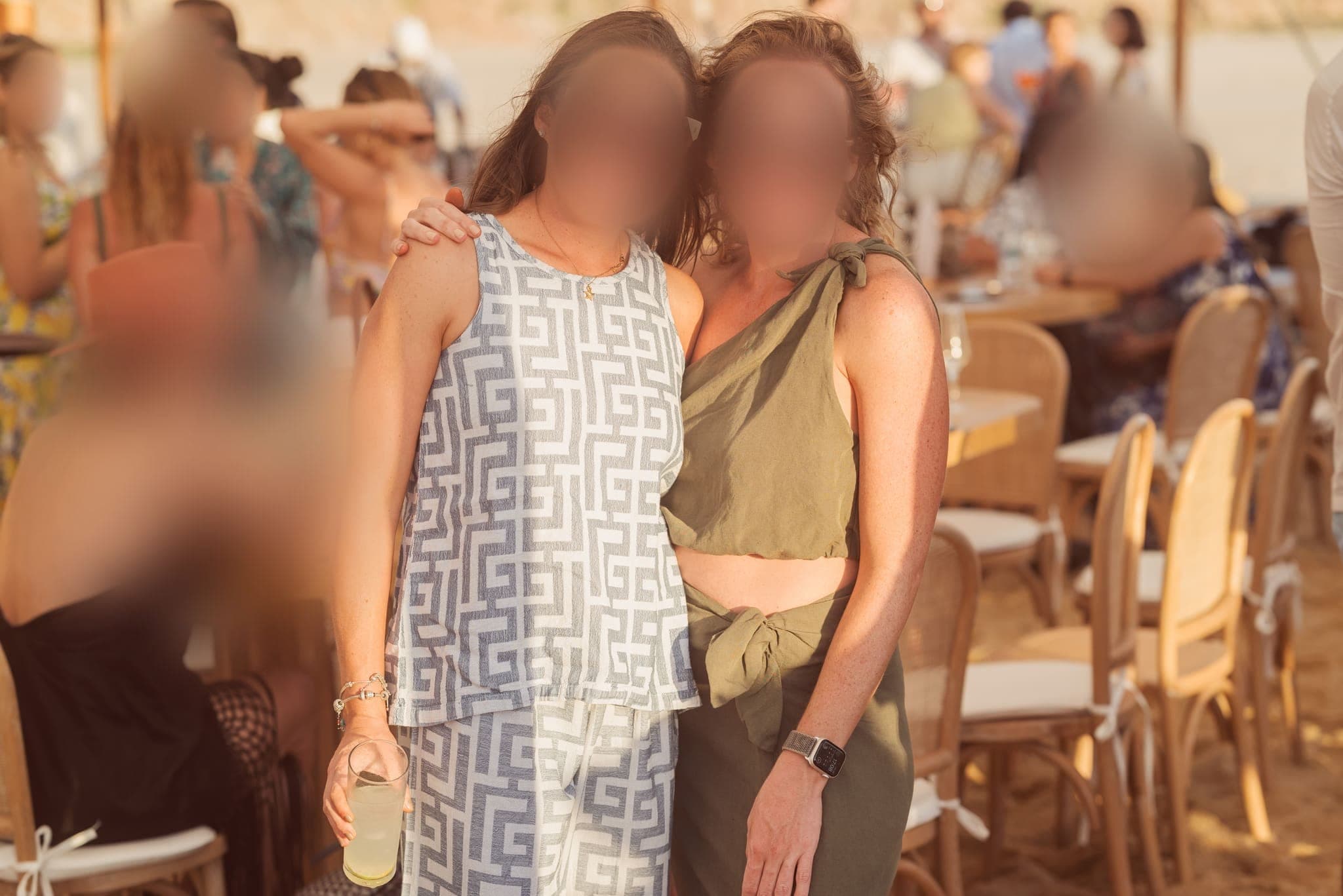 Dos invitadas abrazadas durante la comida en la playa