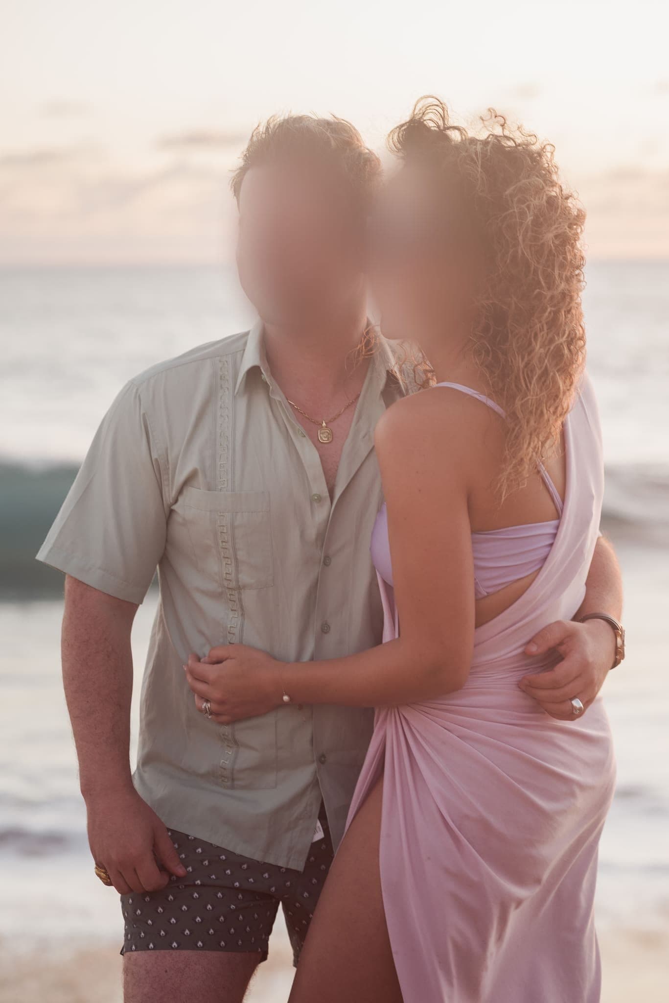 Pareja abrazada frente al mar al atardecer