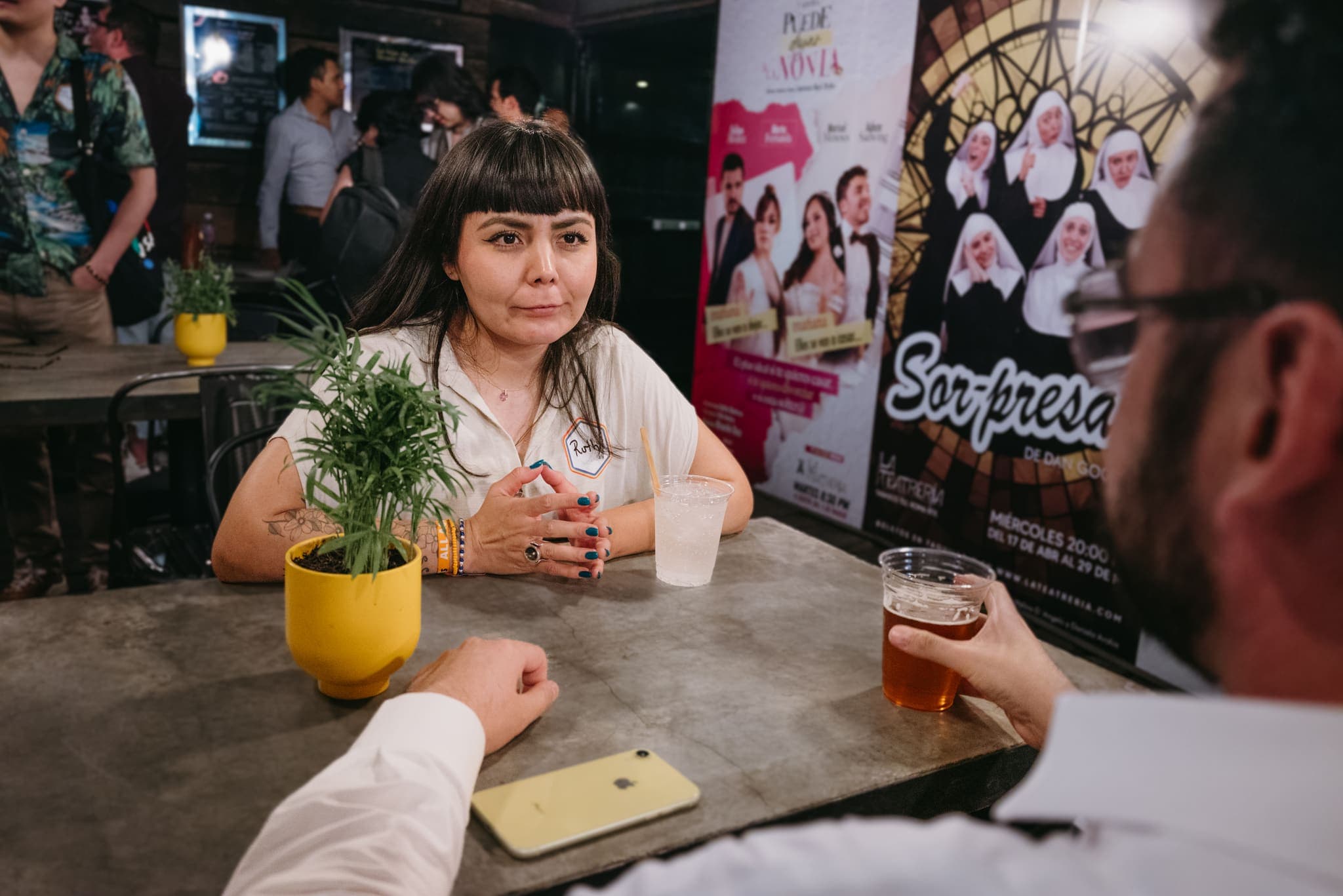 Asistente conversando en la mesa de un bar con luz cálida