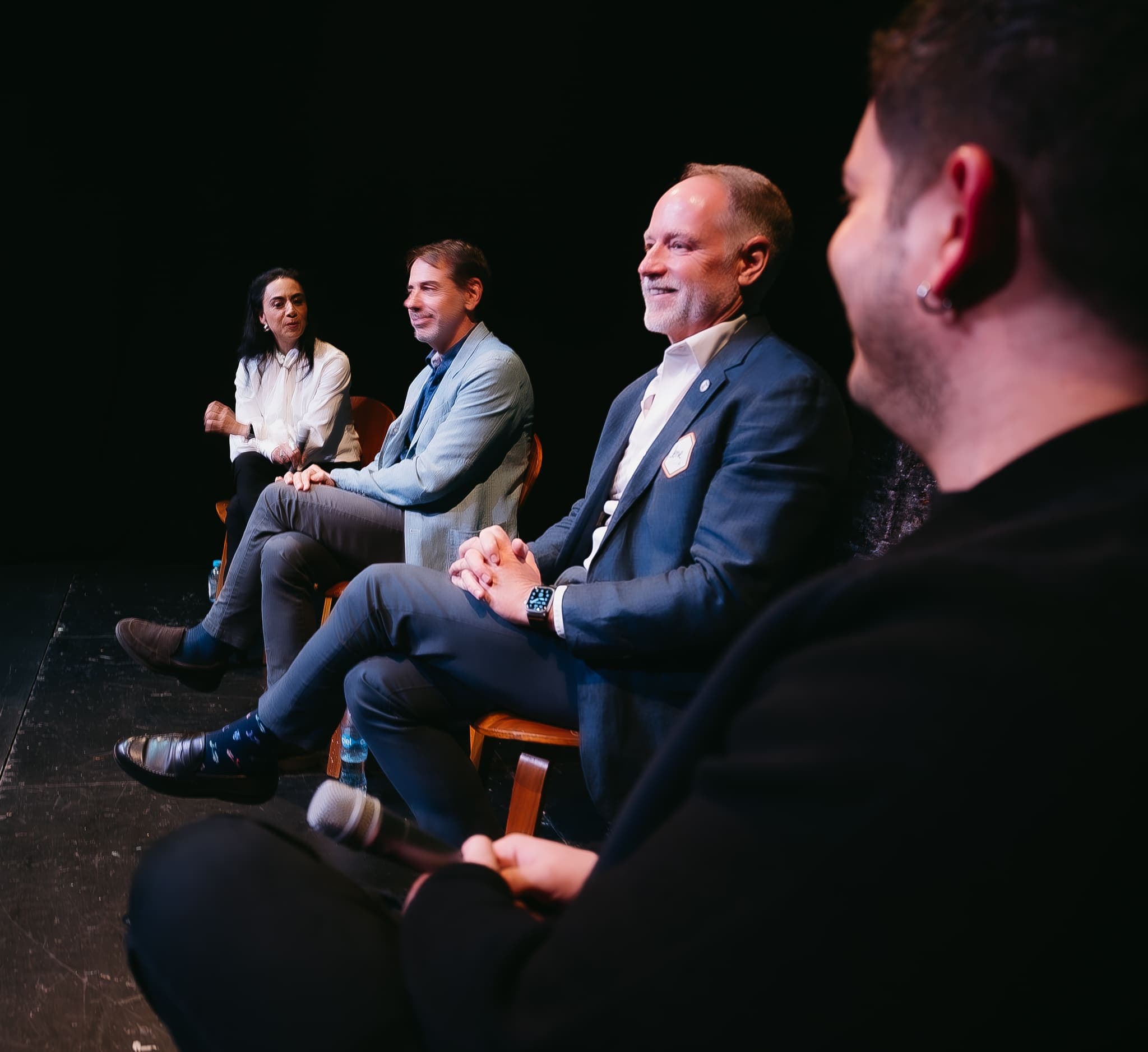 Panelistas riendo durante conversatorio en el escenario
