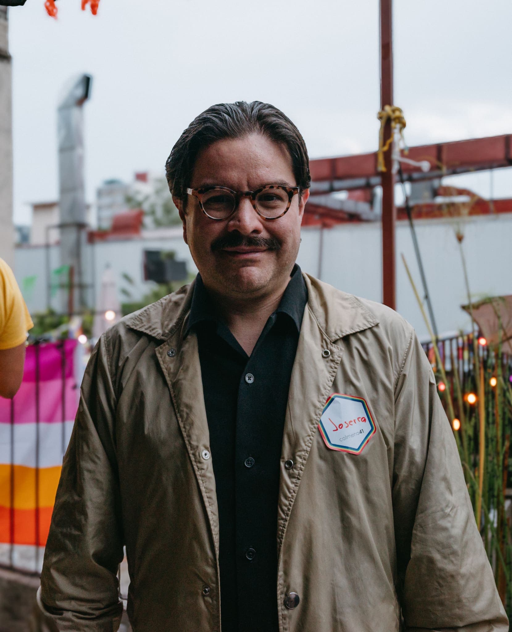 Retrato de asistente con gabardina en el patio del evento