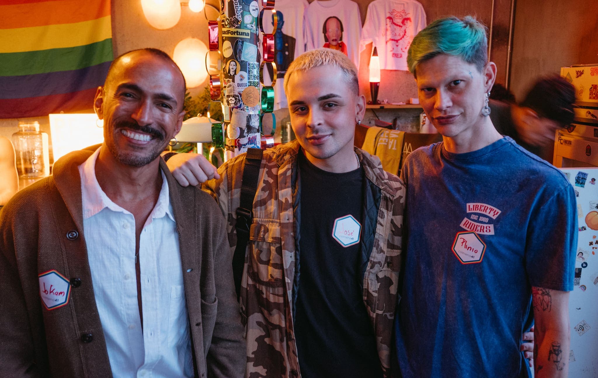 Tres asistentes sonrientes en el bar del evento