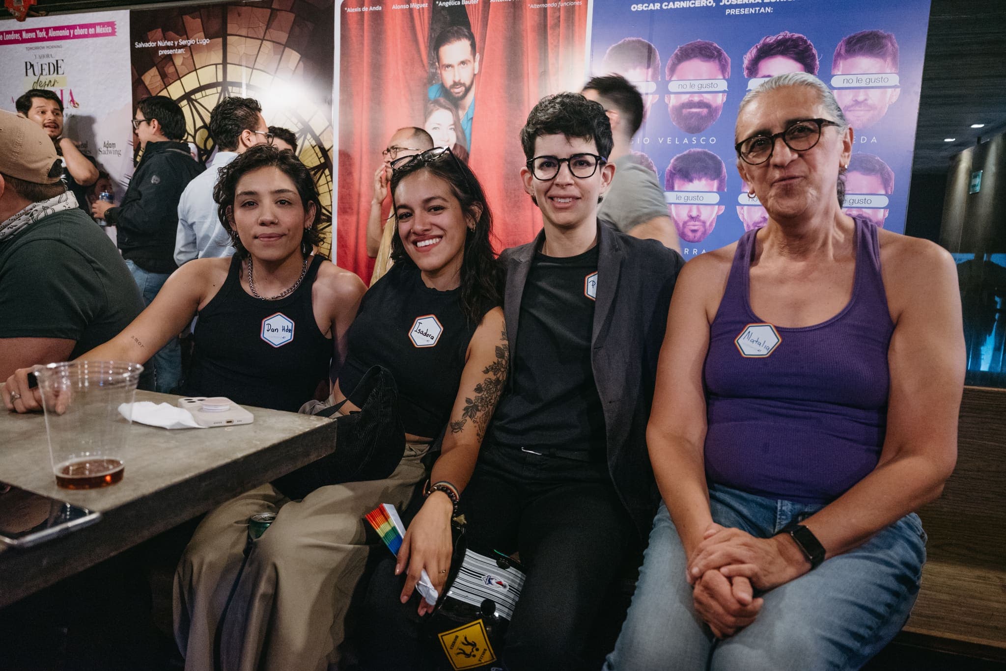 Cuatro asistentes sonrientes sentadas frente al escenario
