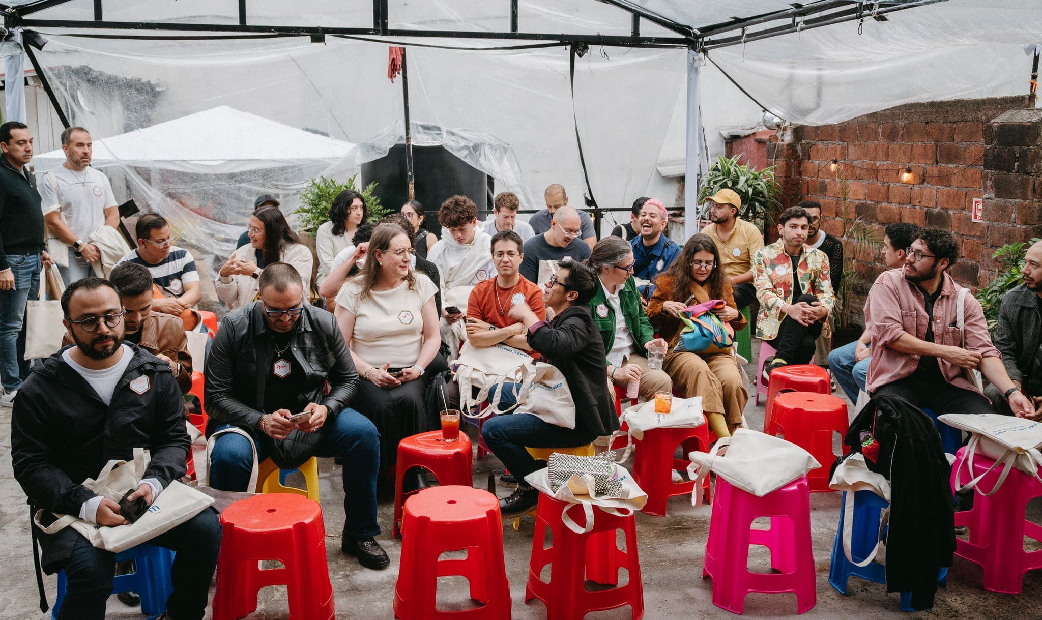 Público en la terraza del evento entre bancos rojos y plantas