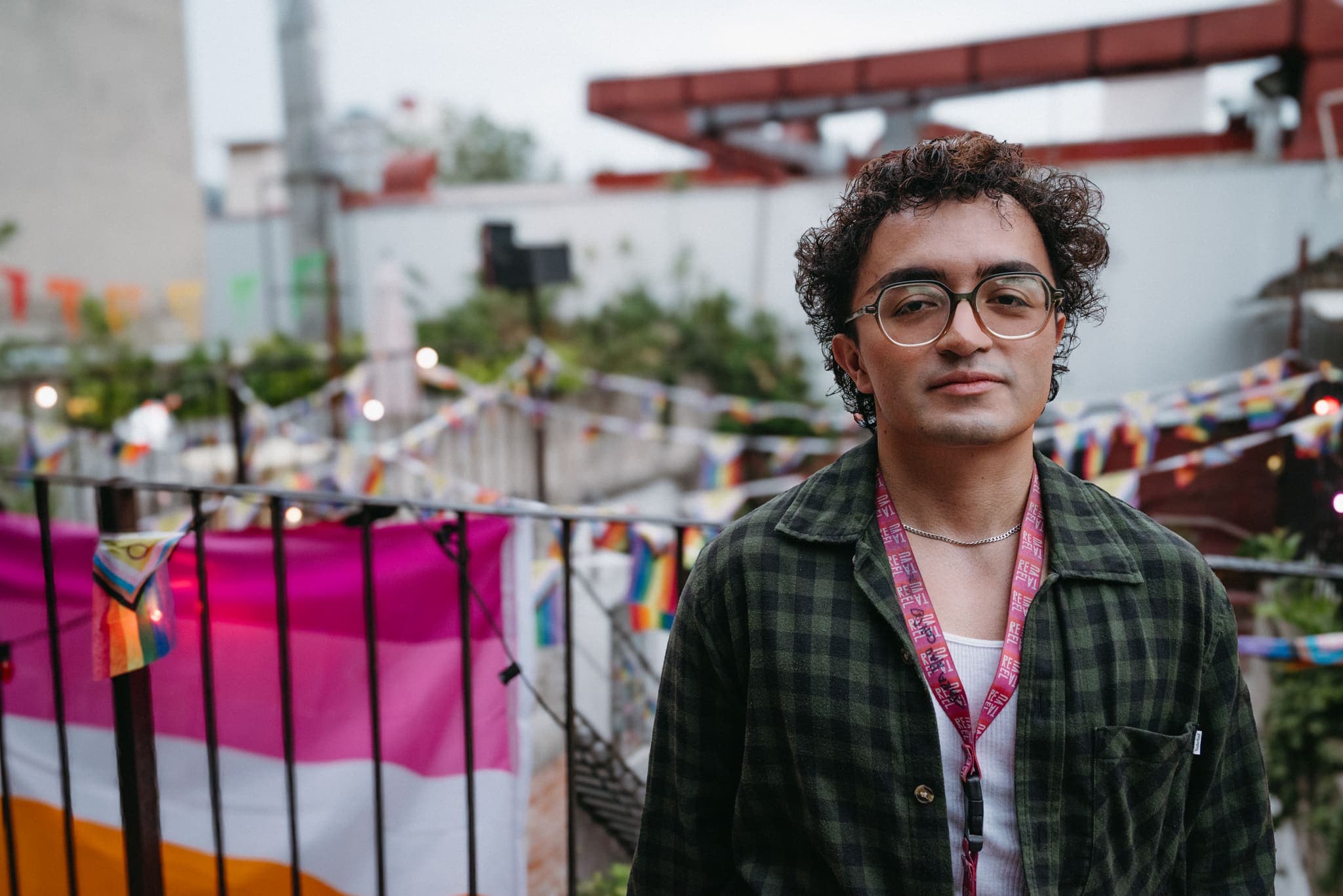 Retrato de asistente con banderas de orgullo al fondo en la terraza