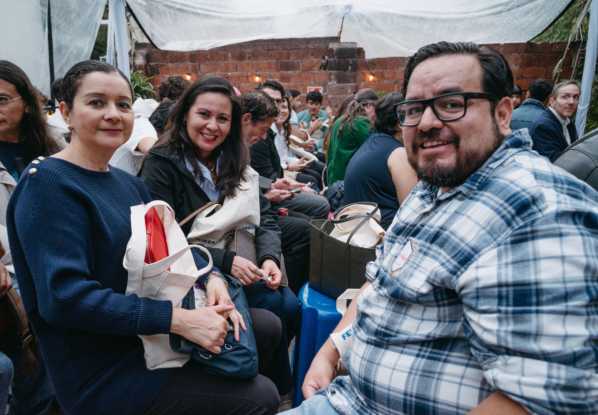 Asistentes sonrientes escuchando la charla en la terraza