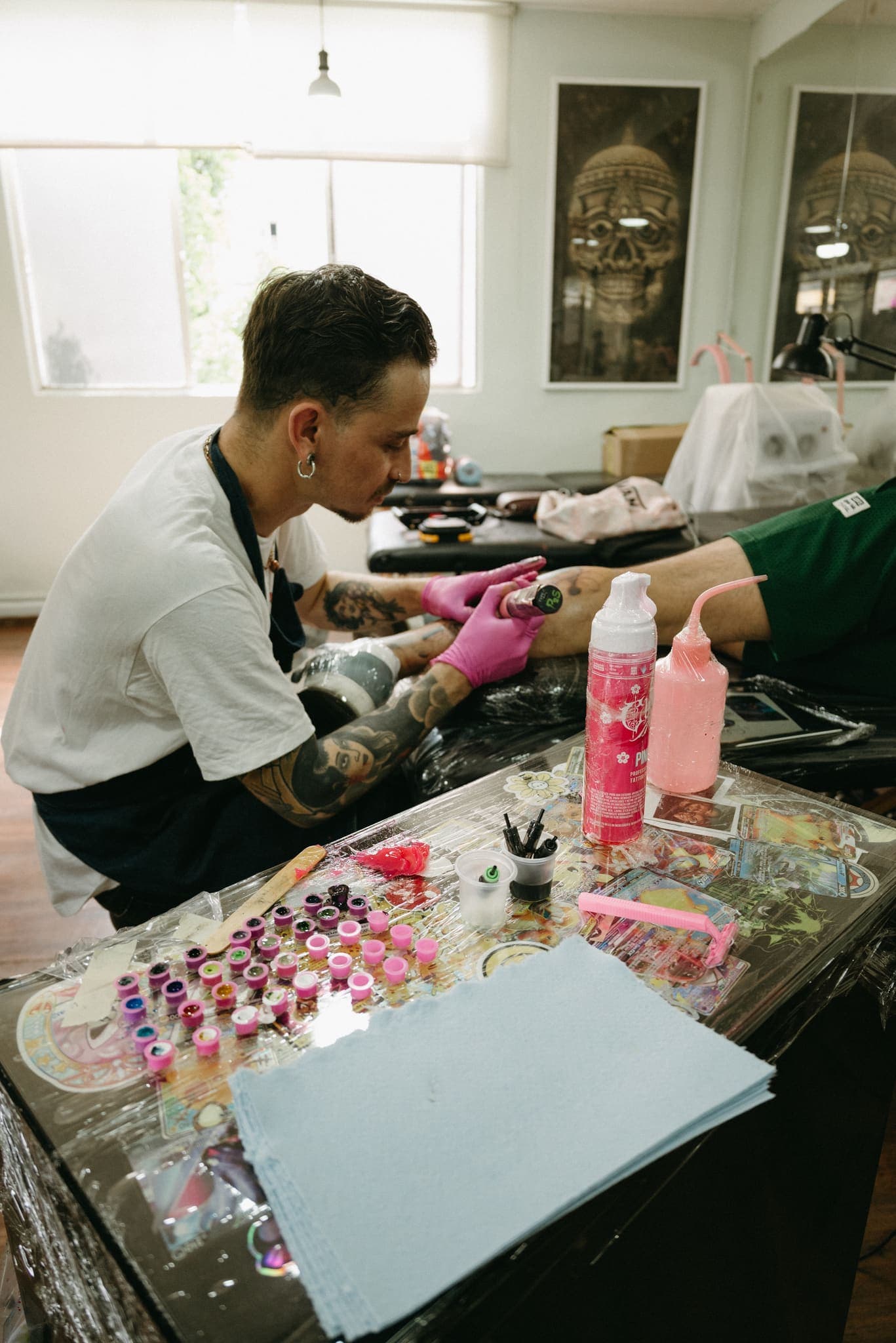 Estudio de tatuaje en plena sesión, mesa de tintas de colores