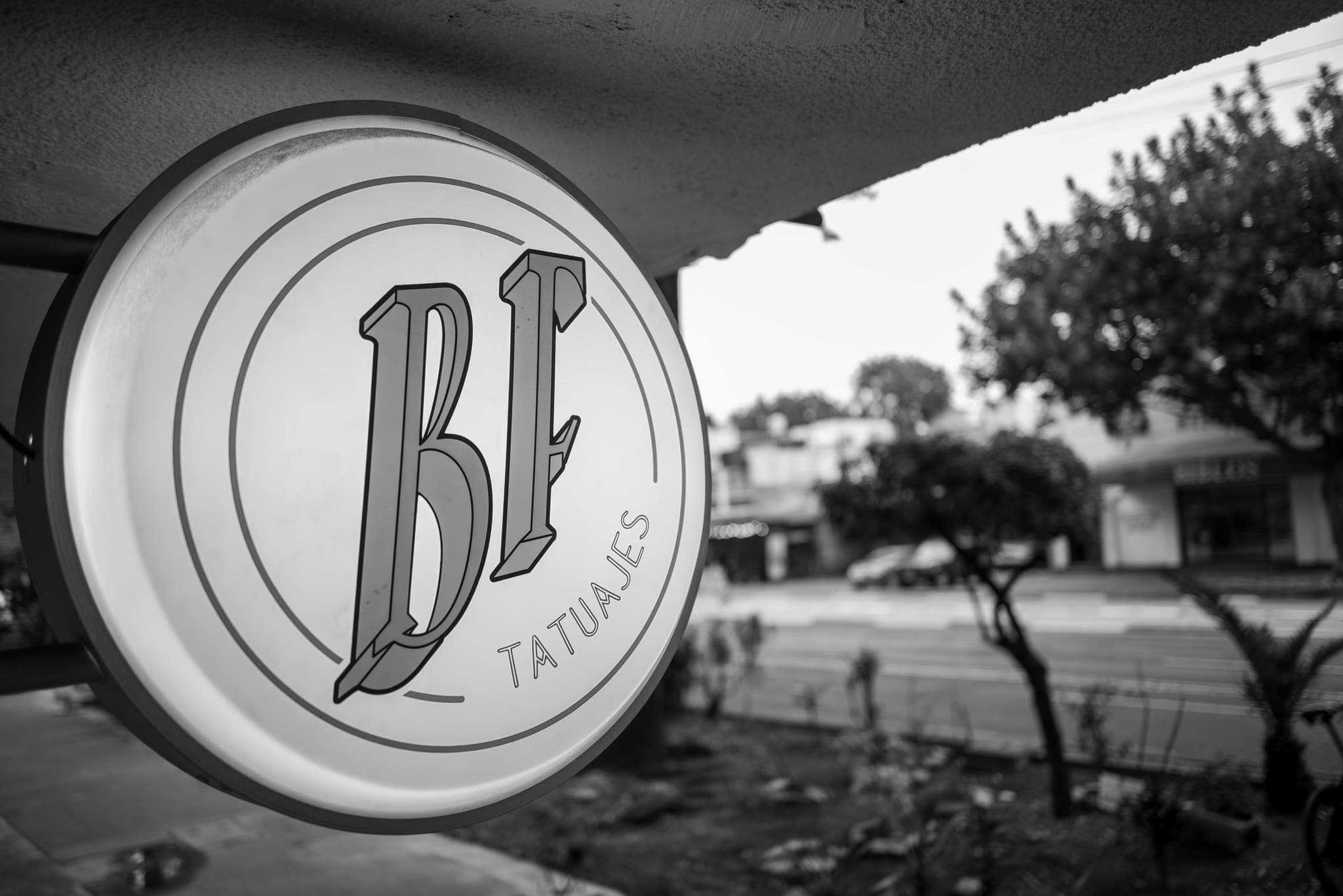 Letrero circular del estudio contra el cielo, blanco y negro