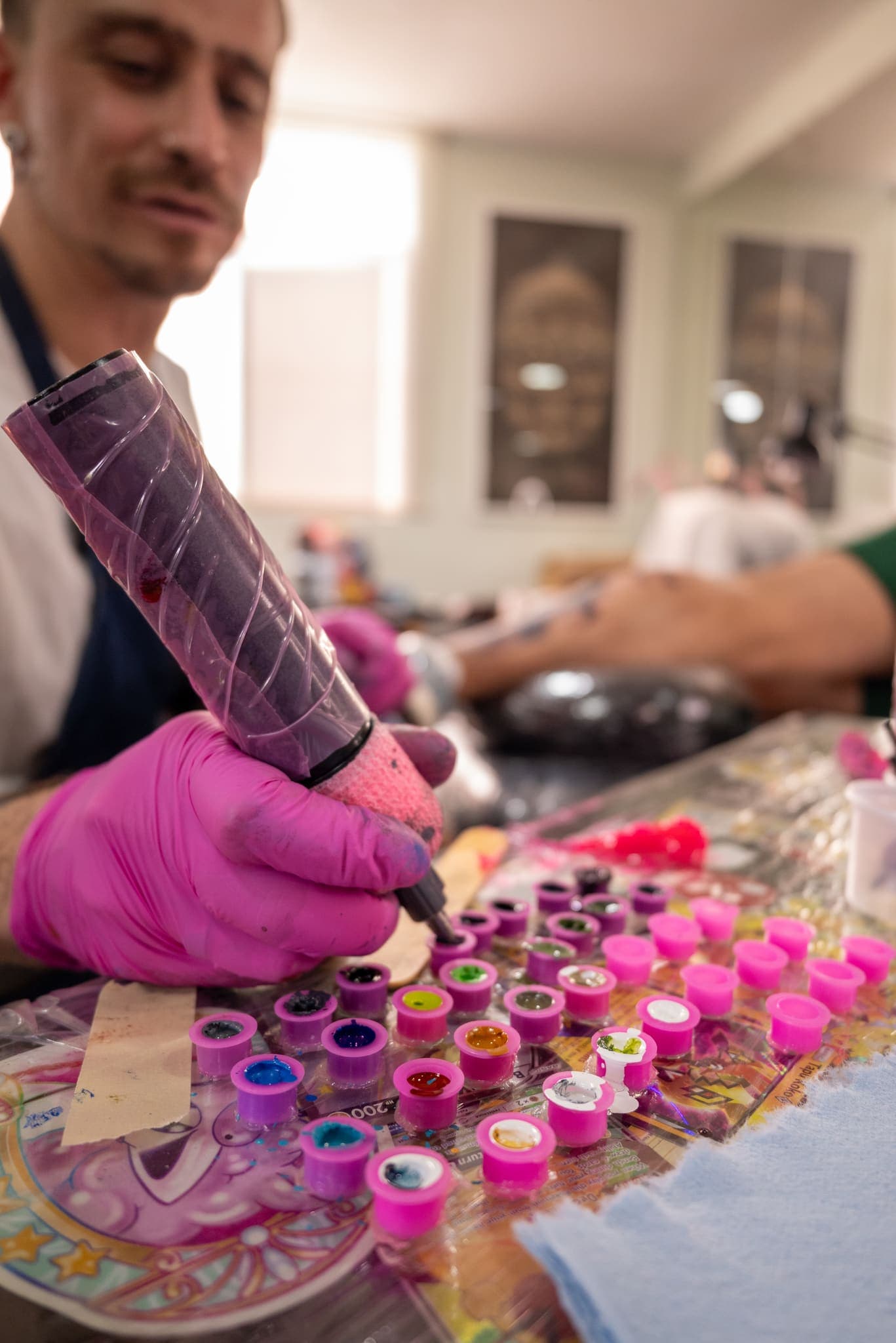 Detalle de manos preparando la máquina sobre los botes de tinta