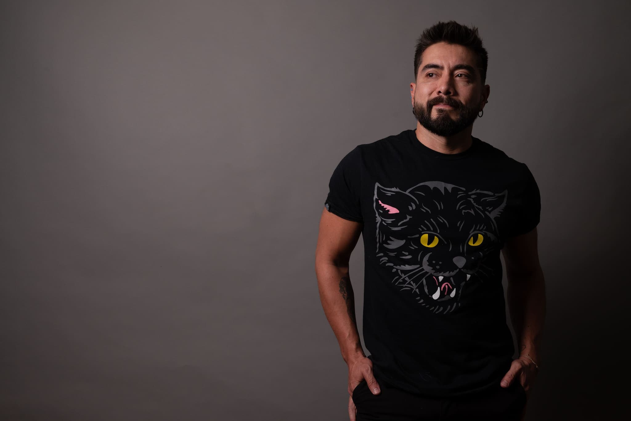 Retrato de estudio sobre fondo oscuro con playera de gato negro
