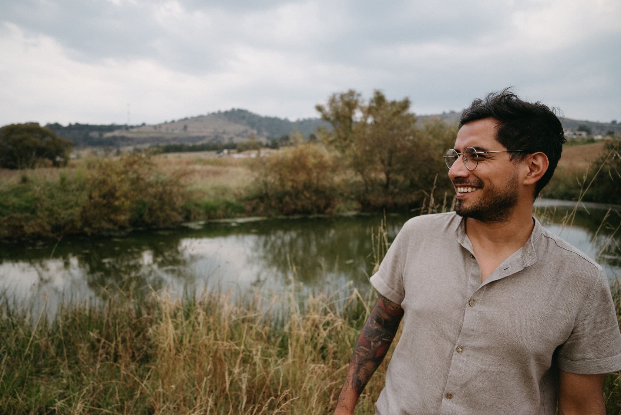 Retrato sonriente a la orilla de un lago al atardecer