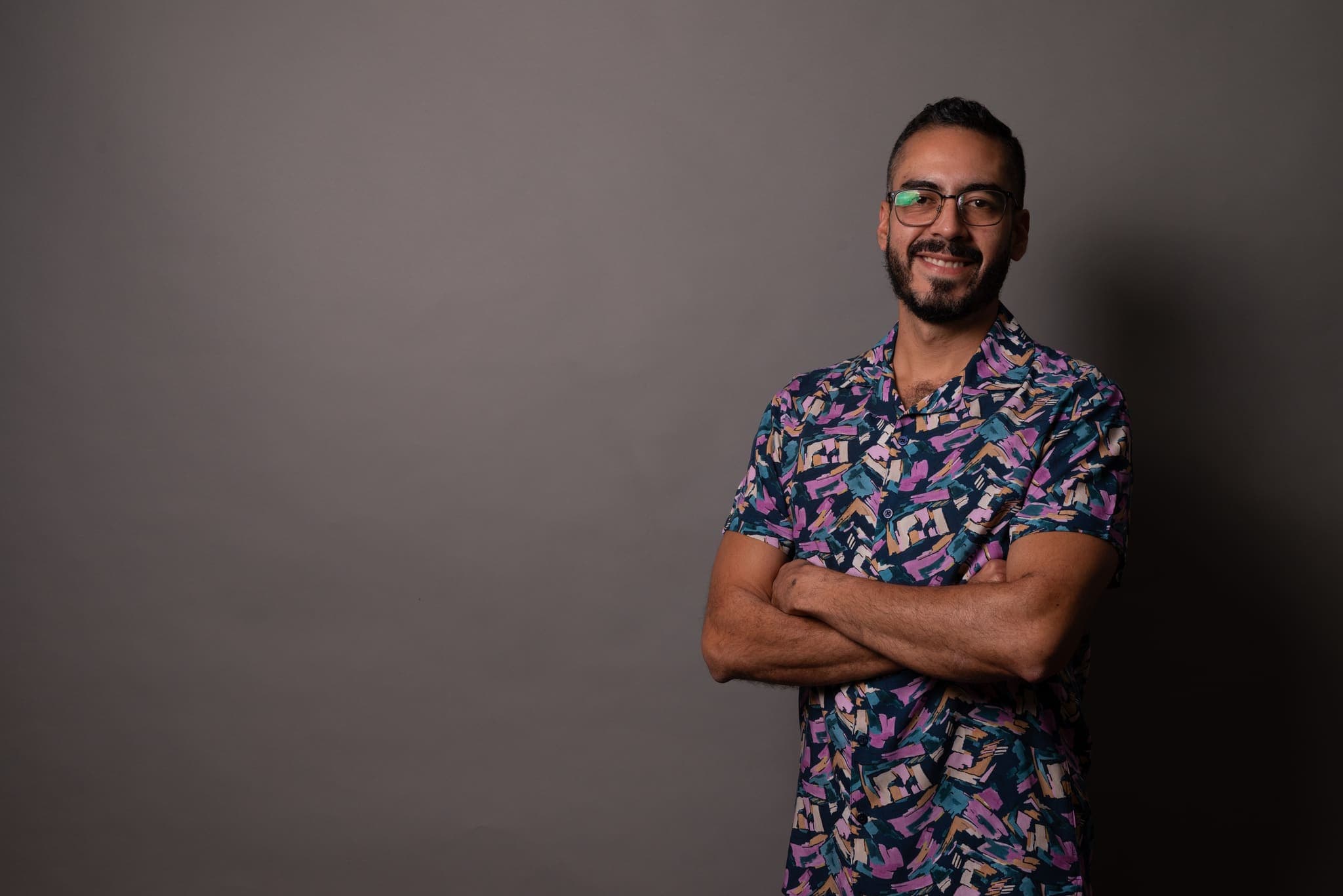 Retrato de estudio con camisa floreada y brazos cruzados